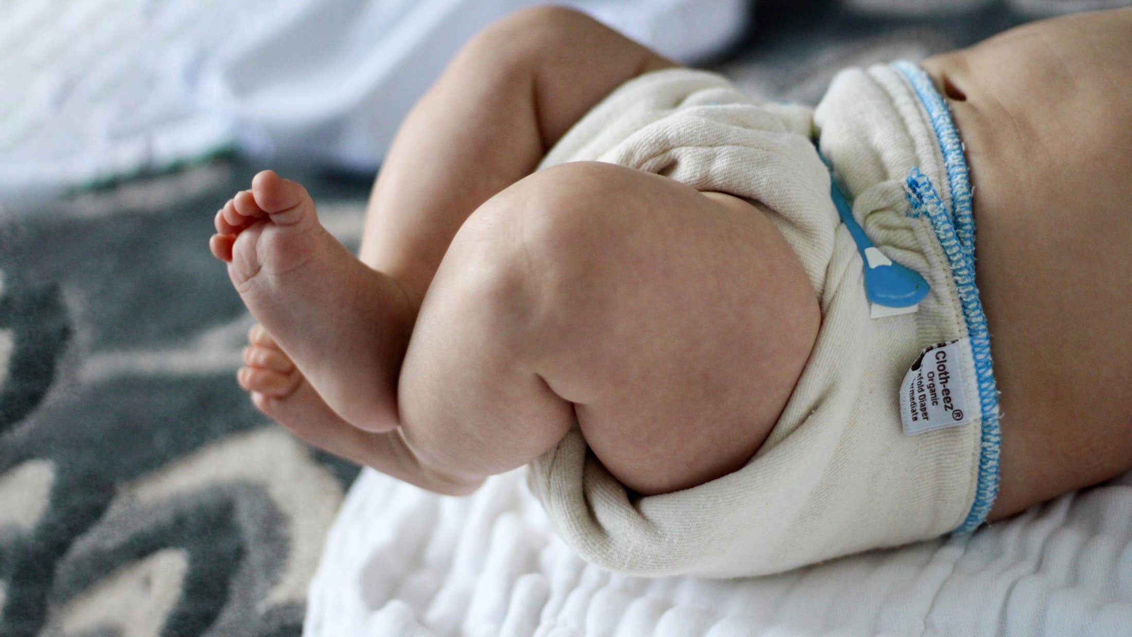 baby in a prefold cloth diaper with snappi fastener