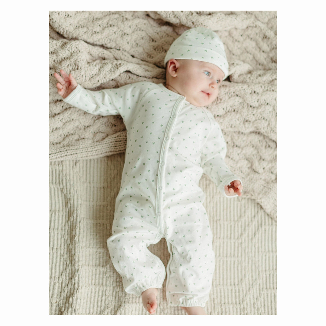 under the nile organic cotton convertible romper set with matching beanie on a baby